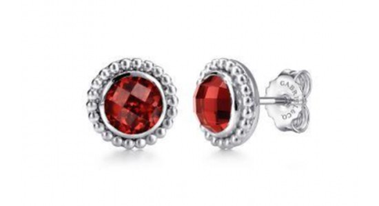 a pair of white gold stud earrings featuring round cut red garnets