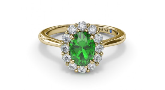 a yellow gold fashion ring featuring a halo set, oval cut emerald
