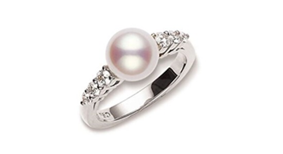 a silver ring featuring a large pearl and diamond accents