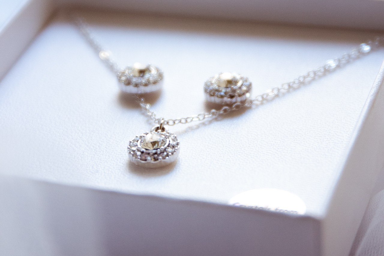 A diamond necklace and matching studs in a jewelry box.