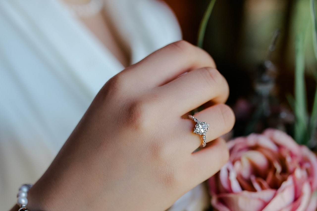 a bride wears an elaborate marquise cut engagement ring.