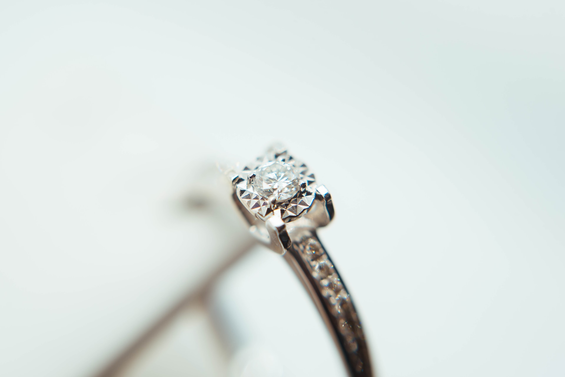 A close up of a small round-cut diamond on an engagement ring.