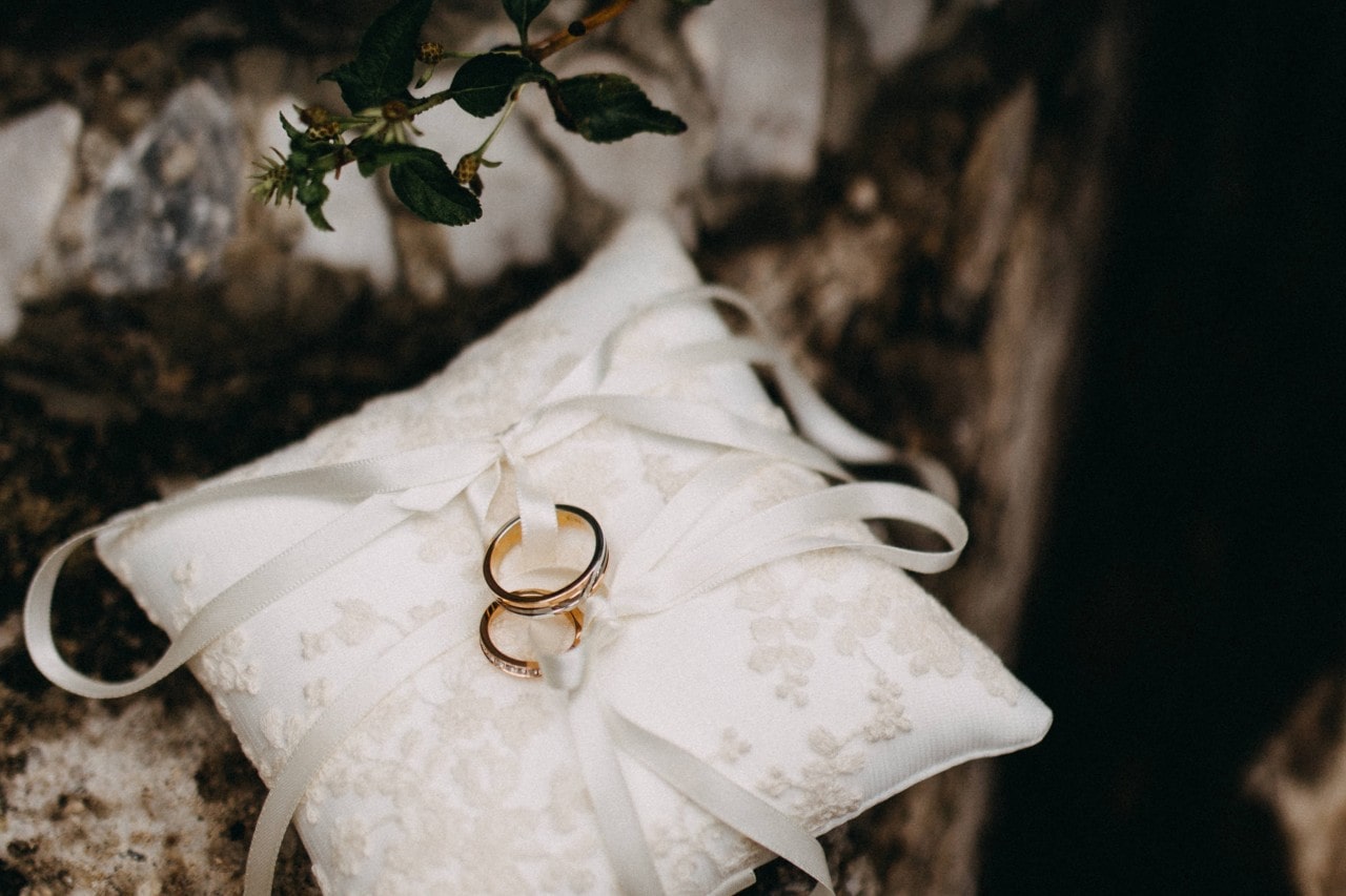 Two wedding rings are tied to the ring bearer's pillow to present to the couple.
